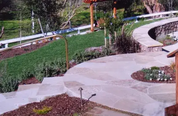 Curved flagstone path with path lighting and planting beds