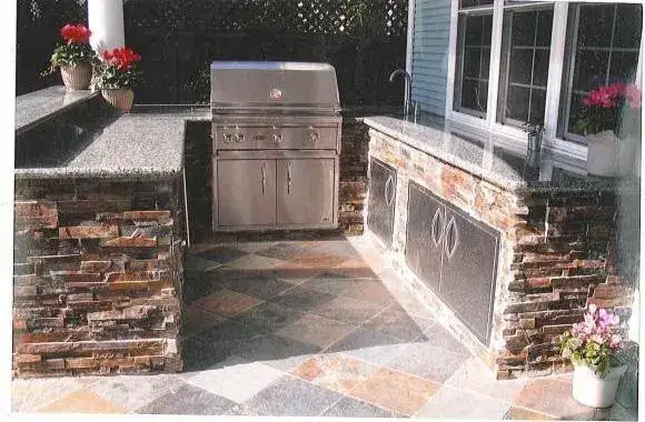 Stone-clad outdoor kitchen with built-in grill
