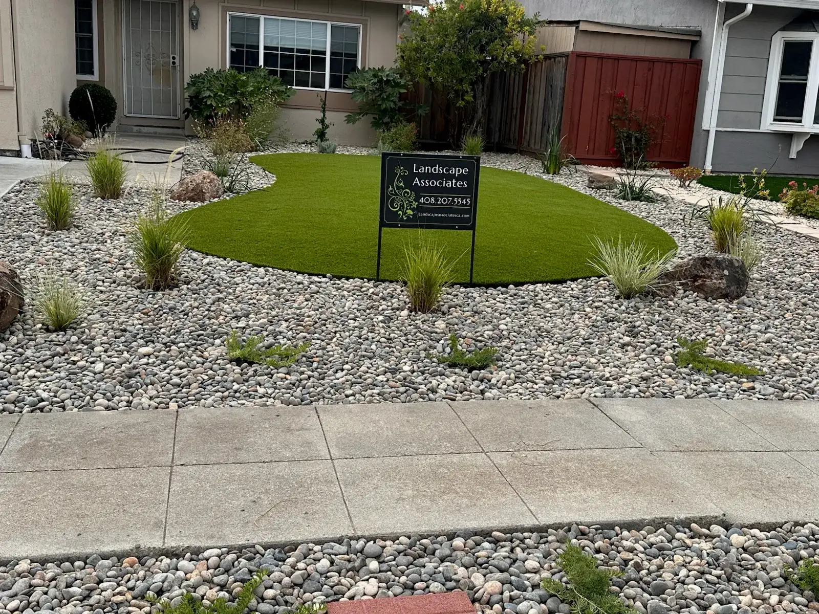 Front yard with artificial turf, river rock and native grasses