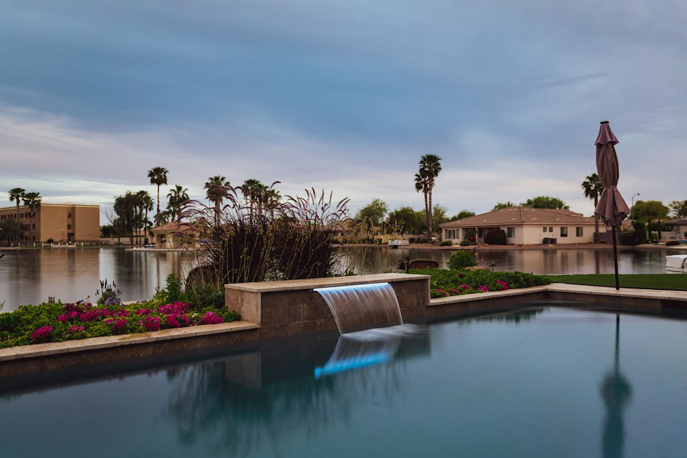 Elegant backyard with a concrete infinity pool overlooking a lake, showing how concrete features can enhance outdoor luxury.