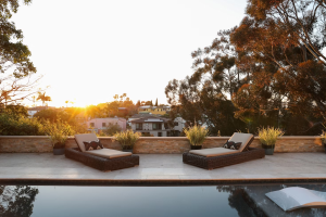 A small retaining wall with lounging chairs against it.