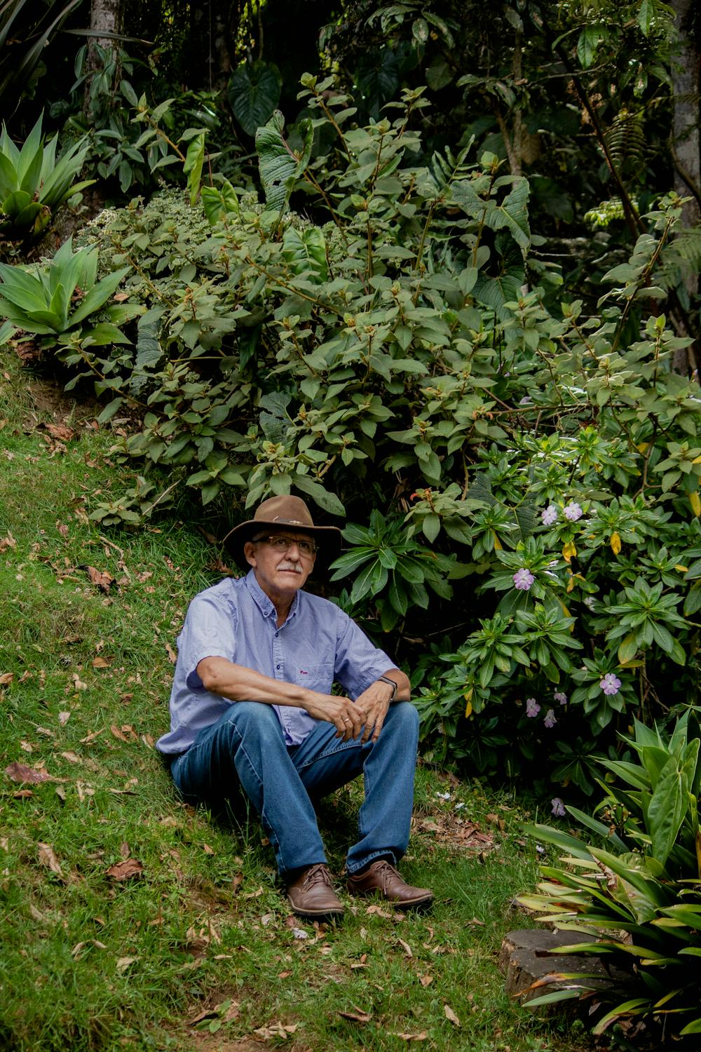A man sits on a well-made garden slope.