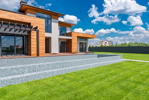 Courtyard of a modern villa with custom hardscape design, vibrant lawn installation, and artistic landscaping elements.