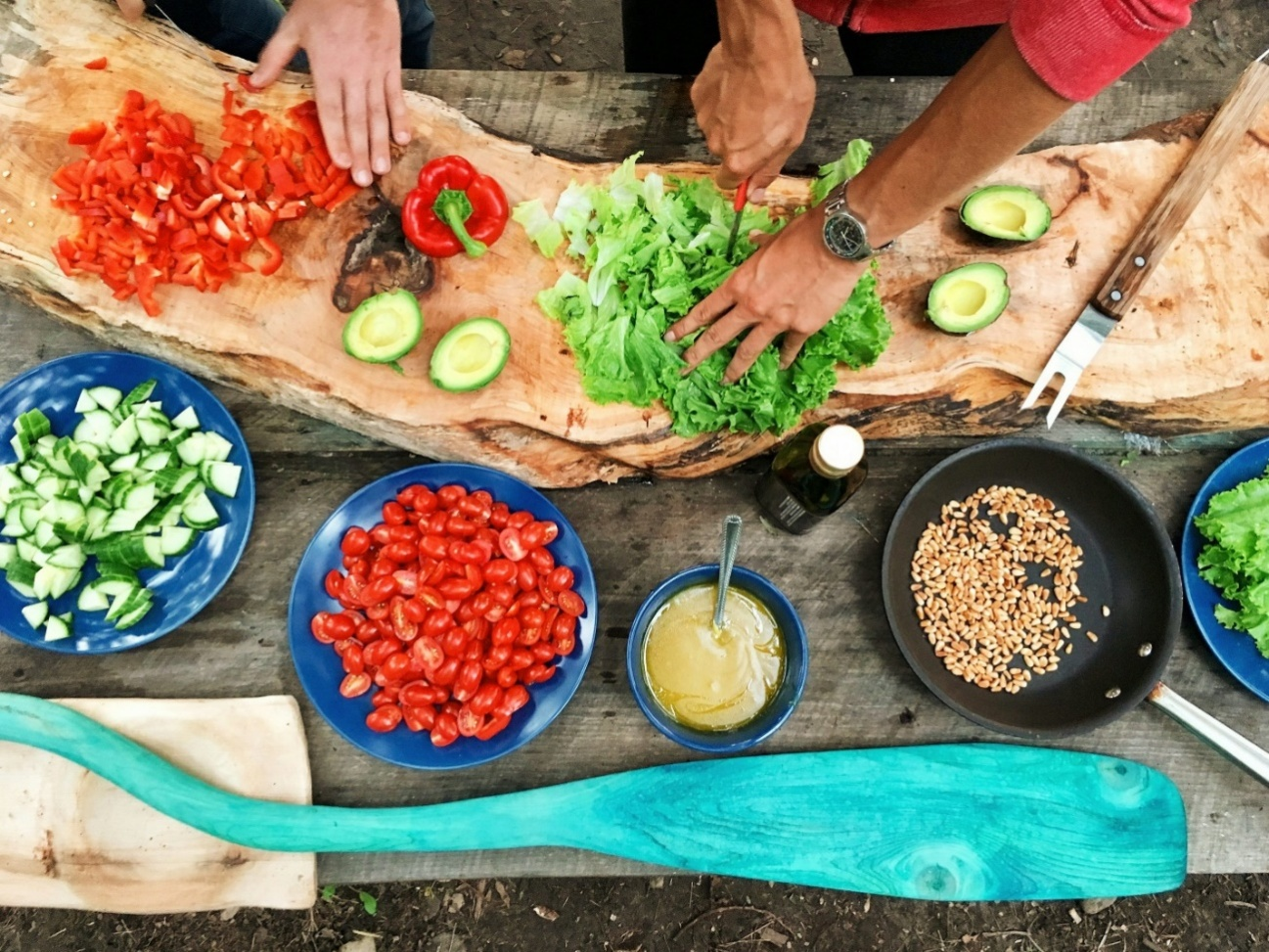 People-cutting-vegetables Group of people cutting vegetables on a countertop in an outdoor kitchen with functional landscaping.